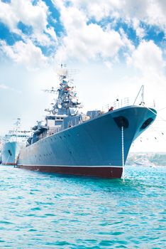 Military navy ship in the bay against blue sky