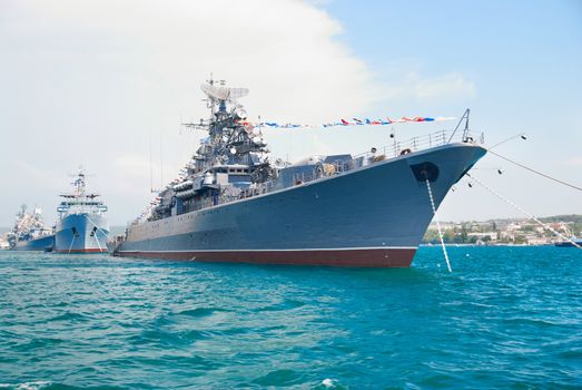 Military navy ship in the bay against blue sky