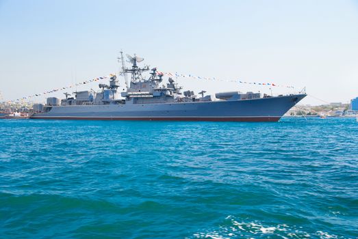 Military navy ship in the bay against blue sky