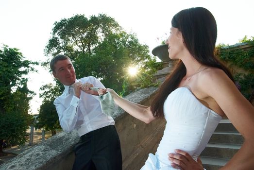 Beautiful wedding couple. Bride pulling groom by the tie