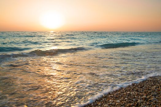 Sunset above the sea. Big sun and waves at beach