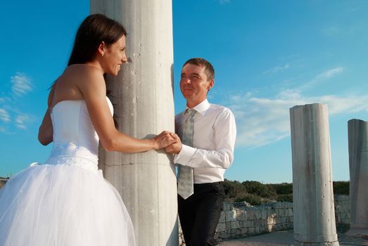 Beautiful wedding couple- bride and groom near greece column in the ancient city