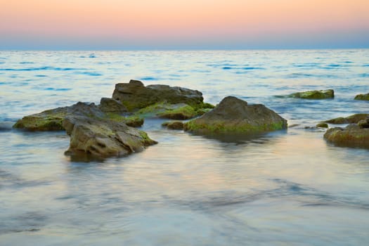 Rocks in the sea against beautiful sunset