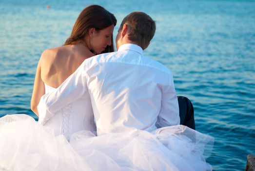 Beautiful wedding couple- bride and groom hugging at the beach. Just married