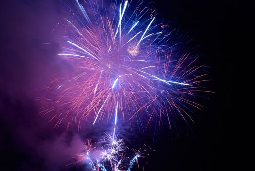 Blue colorful holiday fireworks on the black sky background.