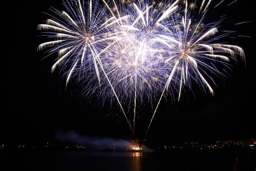 Red and purple colorful holiday fireworks on the black sky background.