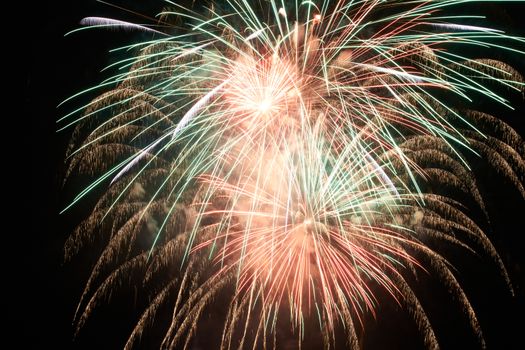 Red colorful holiday fireworks on the black sky background.