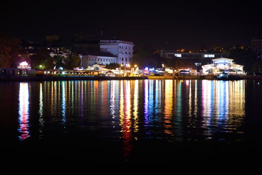 Colorful city illumination at night. View from the seafront