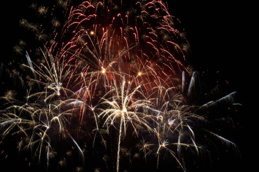 Red colorful holiday fireworks on the black sky background.