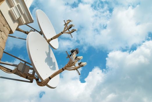 Satellite antenna on the wall with blue sky