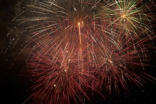 Red colorful holiday fireworks on the black sky background.