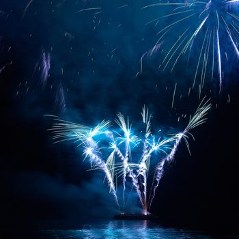 Blue colorful holiday fireworks on the black sky background.