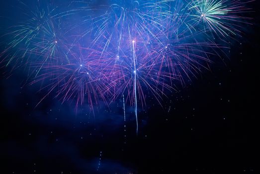 Colorful holiday fireworks on the black sky background.