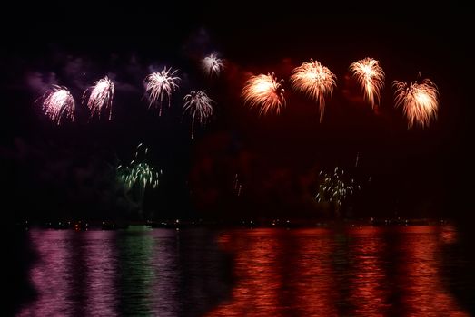 Red colorful holiday fireworks on the black sky background.