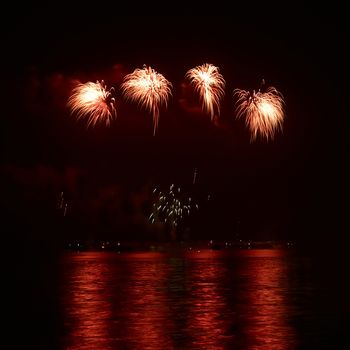 Red colorful holiday fireworks on the black sky background.