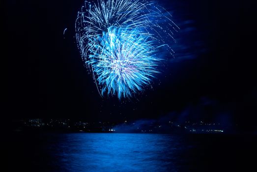 Blue colorful holiday fireworks on the black sky background.