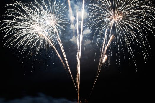 Red and purple colorful holiday fireworks on the black sky background.