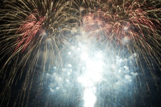 Red colorful holiday fireworks on the black sky background.