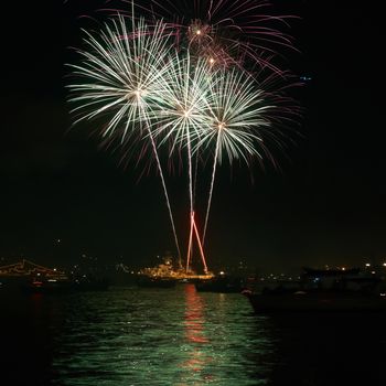 Red colorful holiday fireworks on the black sky background.