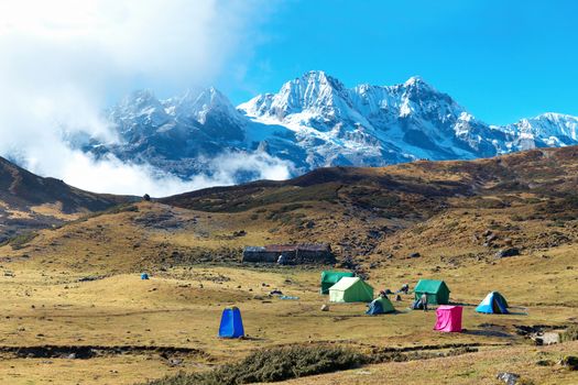 Campsite with tents on the top of high mountains, covered by snow. Kangchenjunga, India.