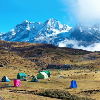 Campsite with tents on the top of high mountains, covered by snow. Kangchenjunga, India.