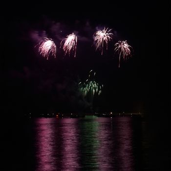 Red colorful holiday fireworks on the black sky background.