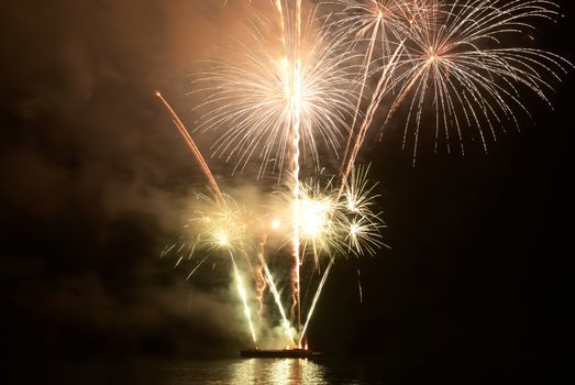 Yellow colorful holiday fireworks on the black sky background.