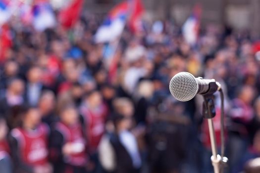 Microphone in focus against unrecognizable crowd