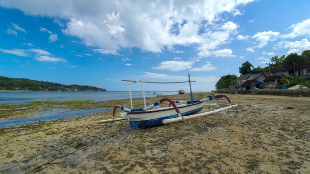 Old lonely fishing boat on the coastline of island Bali in Indonesia