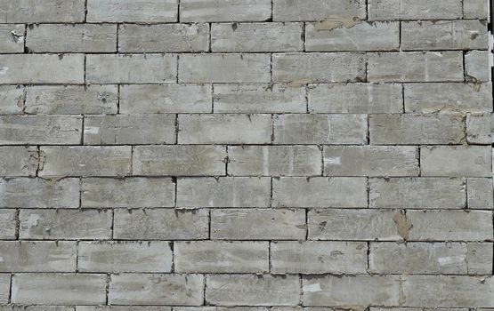 A wall of textured gray construction bricks.