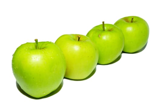 Row of green apples isolated on white.