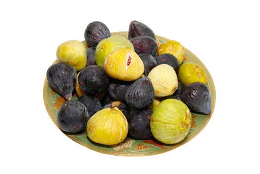 Stack of black and yellow figs on the plate isolated on white.