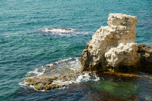 A big white rock and the ocean.