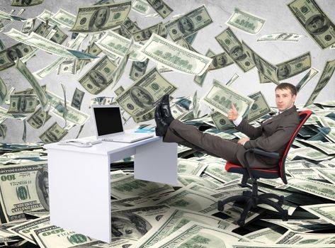 Businessman sitting on chair with table and laptop with legs upon grey background, money rain
