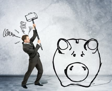 Businessman with hammer and piggy bank on grey wall background