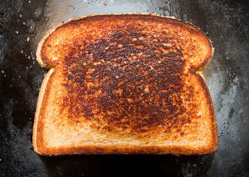 Grilled cheese sandwich that has a slightly burnt look to it