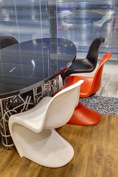 office room with a glass table and multi-colored chairs