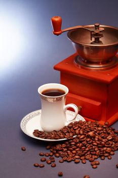 White cup of black coffee near beans and grinder