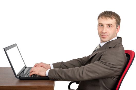 Businessman working on laptop with blank screen and looking at camera isolated on white background