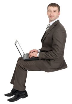 Smiling businessman working on laptop and looking at camera isolated on white background 