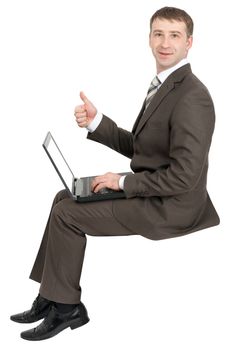 Smiling businessman working on laptop and showing ok isolated on white background 