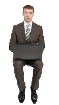Businessman sitting on empty space with laptop and looking at camera isolated on white background