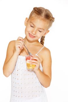 Beautiful little girl with pigtails eating jelly