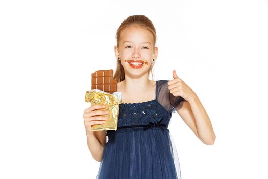 Beautiful blonde girl in a blue dress with curls eating a chocolate