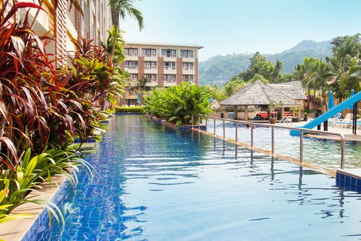 Phuket, Thailand - circa December 2015: Beautiful view of pool zone with green trees and blue water