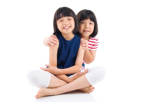 Asian sisters sitting on the floor