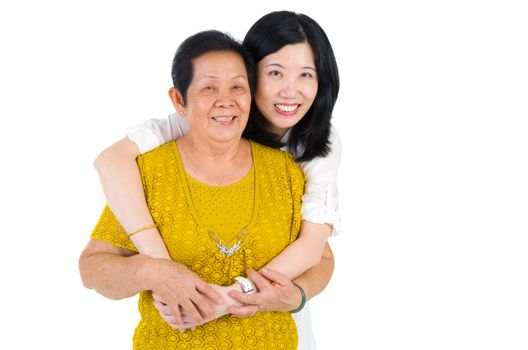 Senior woman and daughter. Happy Asian family senior mother and adult offspring having fun time at indoor studio.