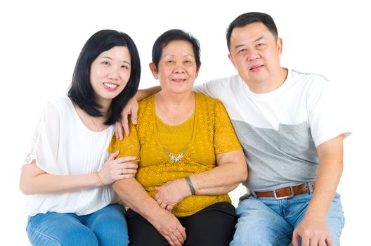 Senior woman with her daughter and son. Happy Asian family mother and adult offspring indoor portrait.