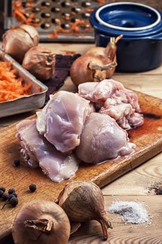 raw fillet of chicken meat and onions in the process of cooking food