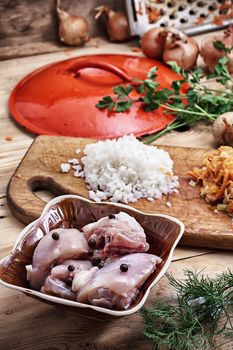 raw fillet of chicken meat and onions in the process of cooking food